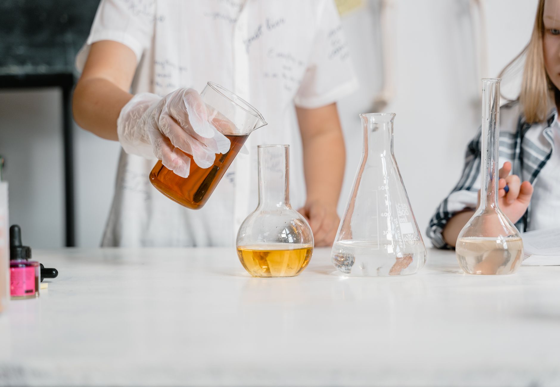 Children in a science lab conducting an experiment with beakers and liquids.