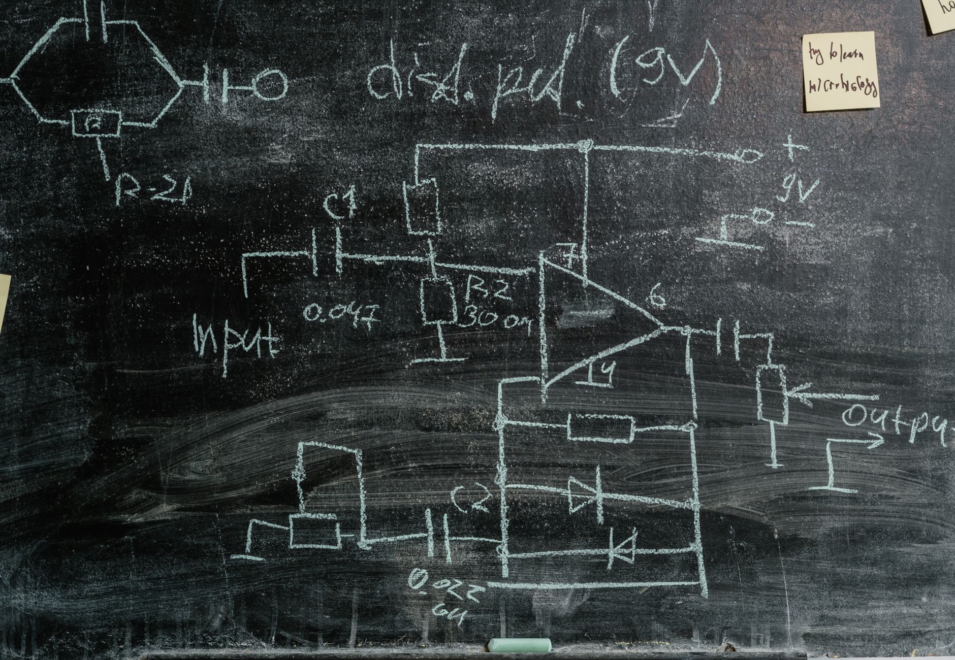 Detailed chalkboard displaying science diagrams and sticky notes, showcasing scientific exploration.